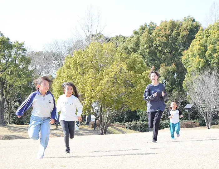 芝生の上で走りながら身体の動かし方を学ぶ様子