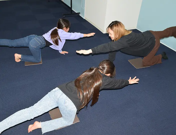 先生と生徒がストレッチで身体の動かし方を学ぶ様子